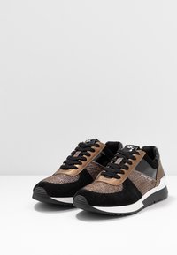 Zapatillas negras y bronce con una mezcla de ante y tejido brillante. Con cordones negros, suela de goma y detalle del logo en el lateral.