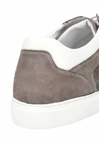 Szare zamszowe sneakersy z białymi skórzanymi akcentami i teksturowanym obcasem. Posiadają widoczne szwy i gumową podeszwę. Skupiają się na eleganckim wzornictwie.