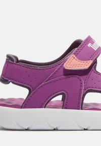 Violetten Sandalen mit einer strukturierten synthetischen Oberseite, kontrastierenden pinken Akzenten, verstellbarem Riemen und einer weißen Gummisohle mit Profil.