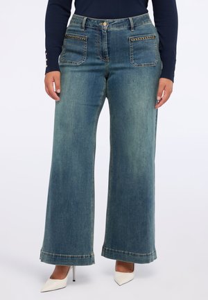 Weite blaue Jeans aus Denim mit zwei Vordertaschen, dekorativen Kettenakzenten und einem rohen Saumabschluss.