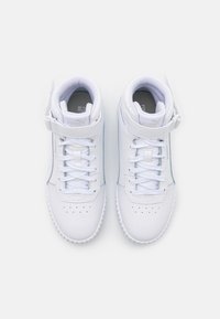 Sneakers alte bianche con tomaia in pelle liscia, punta perforata, cinturino regolabile e lacci piatti, dotati di un interno imbottito.