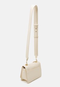 Beige Handtasche mit verstellbarem Träger, mit strukturiertem Oberteil und glatten Seiten. Hardware in Goldoptik und strukturiertes Design.