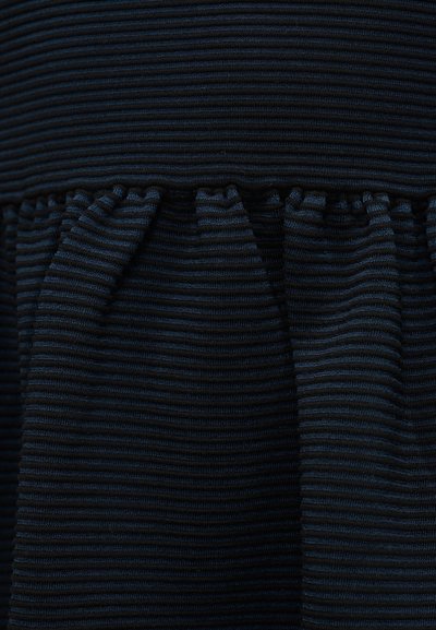 Ριγέ ύφασμα σε σκούρο μπλε και μαύρο με υφή και πτυχώσεις στο κάτω μέρος. Το υλικό φαίνεται μαλακό και ριγωτό.