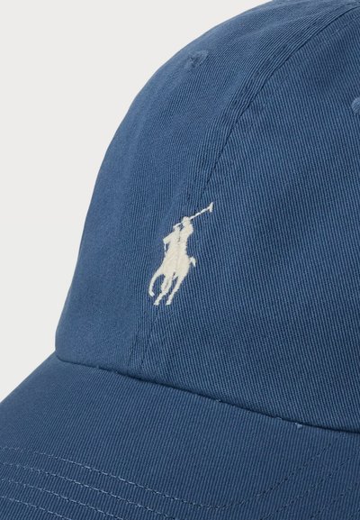 Căciulă de baseball din bumbac albastru, cu o suprafață texturată și un logo brodat alb al unui călăreț. Dispune de o vizor curbat și o curea reglabile.
