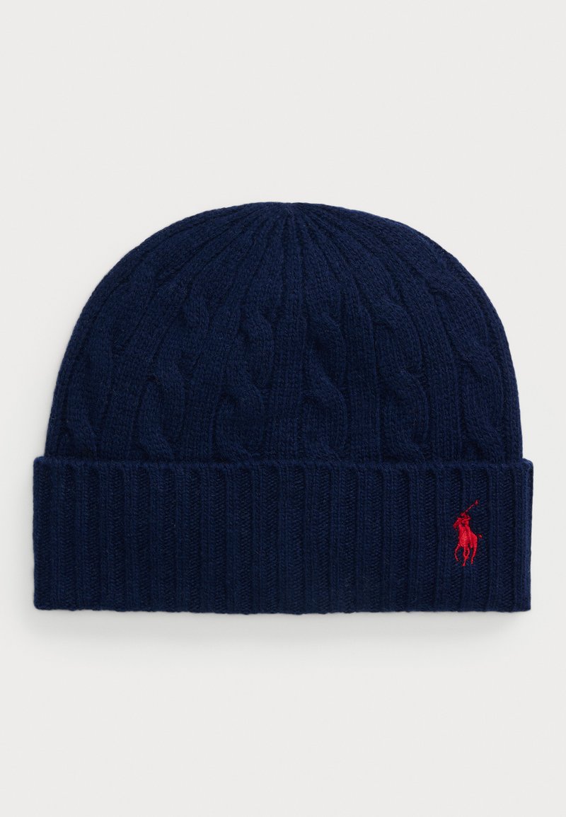 Bonnet en tricot à côtes bleu marine avec un bord rabattu, présentant un petit logo de joueur de polo rouge brodé sur le côté droit à l'avant.