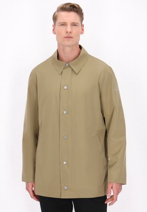Jachetă impermeabilă bej, cu guler larg, închidere cu nasturi, buzunare laterale și mâneci lungi. Textură netedă, design minimalist.