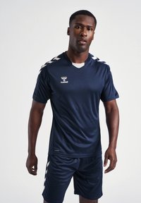Marineblå atletisk trøje med korte ærmer og v-udskæring. Har lysegrå detaljer og logo på brystet. Kombination med matchende shorts.