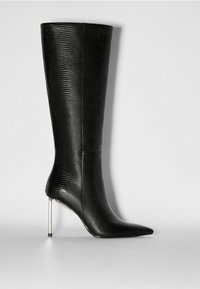 Des bottes noires à talons, montantes jusqu'au genou, avec une texture reptilienne brillante, un bout pointu et un talon aiguille métallique. Surface lisse avec des coutures minimales.