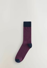 Chaussette à motif géométrique violet avec un revers et des accents de orteil bleu marine. Fabriquée dans un tissu texturé pour la respirabilité et le confort.