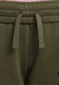 Olive green sweatpants with a drawstring waist, featuring a soft texture and ribbed detailing along the waistband and pockets.