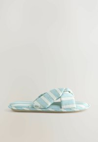 Pantofole in tessuto a righe di colore azzurro e bianco, con un design incrociato, suola imbottita e un sottile logo floreale sul lato.