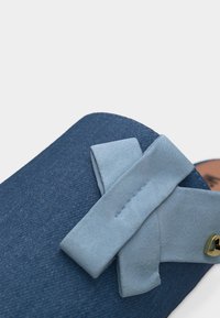 Μπλε σανδάλι από σουέντ με διασταυρωμένους ιμάντες και μικρή χρυσή καρδιά στη πλευρά.