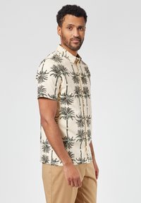 Korte mouwen overhemd met knopen in crème, met een herhalend palmbomenpatroon in zwart en groen. Slim fit en een gladde stofstructuur.