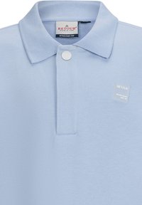 Polo shirt azzurro in morbido tessuto con chiusura a tre bottoni, colletto e un piccolo etichetta del marchio sul davanti.