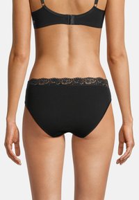 Schwarze hochtaillierte Panties aus glattem Stoff mit einem Spitzenbund. Verfügt über ein nahtloses Design ohne sichtbare Linien.
