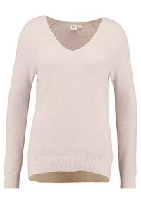 Pull beige clair en maille avec col en V, manches longues, motif texturé et ourlet côtelé ; présente un dos légèrement plus long.