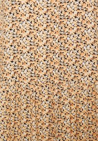 Robe à motif floral dans des couleurs orange, noire et blanche ; tissu léger avec un détail plissé à l'ourlet ; apparence texturée.