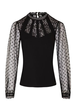 Zwarte top met een kant yoke en sheer mouwen met polkadots. De mouwen hebben een gegolfde rand, wat textuur en een decoratief element toevoegt.