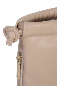 Bolso de cuero beige suave con cierre de cordón, que presenta una textura lisa y una cremallera en tono dorado en el costado para un acceso seguro.