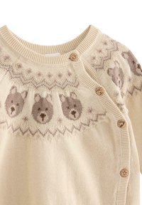 Světle béžový pletený cardigan s obličeji medvídků a zigzagovými vzory. Má dřevěné knoflíky a design s kulatým výstřihem. Měkká textura.