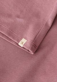 Koszulka z krótkim rękawem w kolorze mauve, charakteryzująca się ryżowym splotem oraz małą metką z literą 'A' blisko dołu.