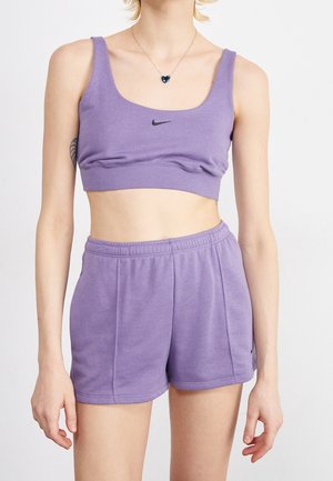 Lilla atletisk crop top med rund halsudskæring og sort Nike-logo, kombineret med matchende shorts med elastisk taljebånd.