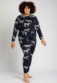 Conjunto de loungewear en color marino que incluye una camiseta de manga larga y leggings con un patrón de cebra blanco. Material suave con puños y cinturilla acanalados.