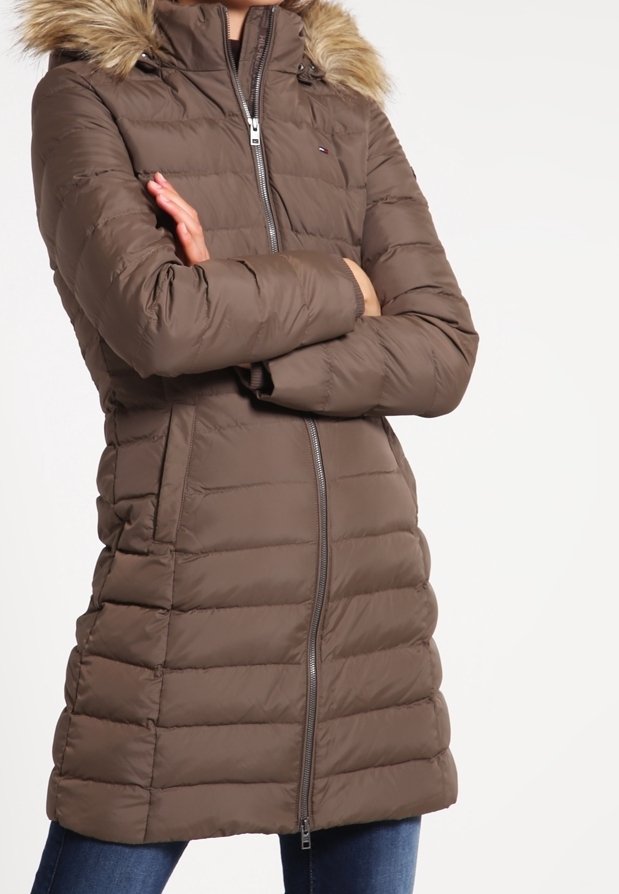 Brązowy puchowy płaszcz z futrzanym kapturem, horyzontalnym pikowaniem, zamek z przodu i bocznymi kieszeniami. Miękka tekstura i średniej długości krój.