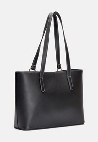 Czarna skórzana torba na ramię o gładkiej fakturze, z podwójnymi paskami na ramię i kontrastowym białym przeszyciem wzdłuż krawędzi oraz pasków.