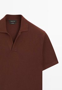 Brun bomulds polo shirt med en lille krave og korte ærmer. Har et nakkeetiket, glat tekstur og et enkelt, klassisk design.