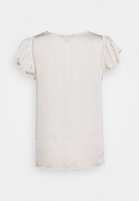 Ljusbeige blus med korta, rynkade ärmar, mjuk textur och rund halsringning. Sömmar på baksidan ger en diskret intresse.