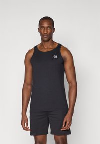 Svart bomullstopp med rund hals, med en liten logo på brystet. Kombinert med svarte shorts, begge har en glatt tekstur.