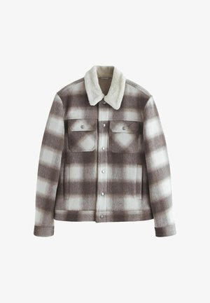 Barna és fehér kockás farmerdzseki műszőrme gallérral, két mellzsebbel, patent gombokkal és oldalsó zsebekkel.