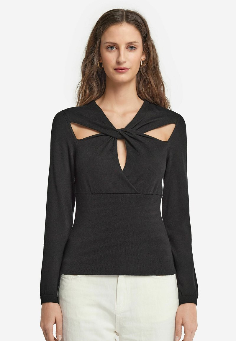 Svart långärmad topp med en knuten design och utskärningar vid axlarna och bröstet, tillverkad av strukturerad, stretchig tyg.