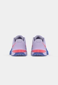 Pantofi sport violeți cu o textură netedă, accente roz și tălpici albastre. Prezintă un guler căptușit și marca "METOON" pe călcâi.