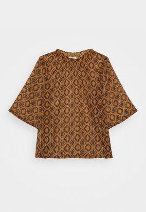 Blouse marron avec motif géométrique en losange noir, manches larges trois-quarts et encolure froncée.