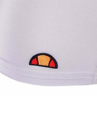 Chemise gris clair avec un logo rond multicolore brodé comportant des segments rouges et orange en bas à gauche. Texture lisse, design ajusté.