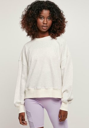 Lys grå oversized sweatshirt med teksturert finish, ribbede mansjetter og rund hals, sammen med lavendelshorts.