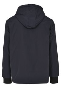 Chaqueta con capucha en color marino, fabricada con un tejido suave y ligero. Presenta puños elásticos y un diseño trasero limpio, adecuado para el uso casual.