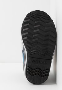 Suola in gomma nera con un motivo a zig zag, dotata di logo "SOREL" in rilievo, progettata per offrire trazione e durabilità.