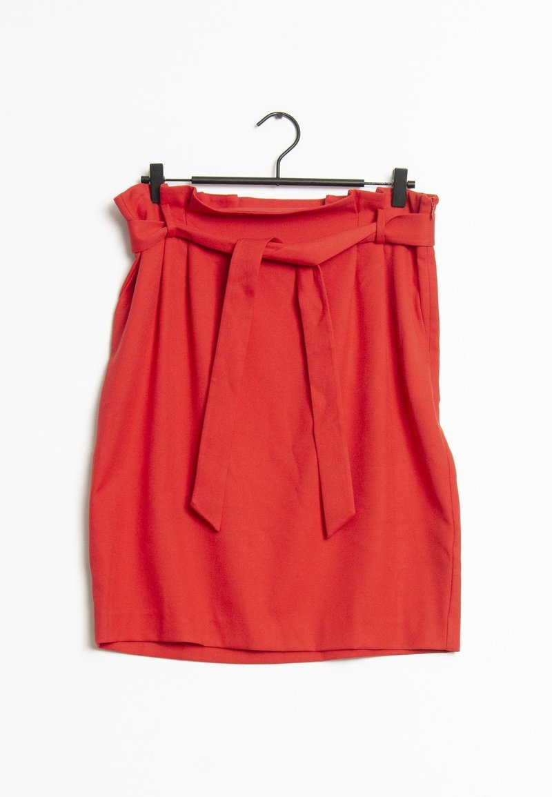 Rode hoge taille rok met plooien en een bijpassende stoffen riem geknoopt aan de voorkant, hangend aan een zwarte hanger tegen een witte achtergrond.