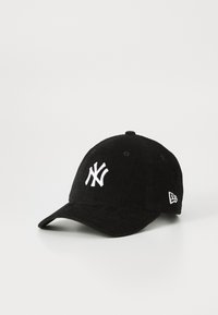 Casquette de baseball en velours côtelé noir avec un logo NY blanc brodé à l'avant et le logo New Era sur le côté, présentée sur un fond blanc.