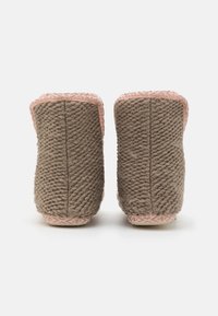 Brown knitted boots with a textured finish and pink trim, featuring a sturdy sole with geometric patterns. Back view.
