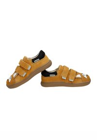 Scarpe di camoscio giallo con retro nero, dotate di tre cinghie in velcro. Un design di faccia di animale bianca decora la punta. Suola in gomma testurizzata.