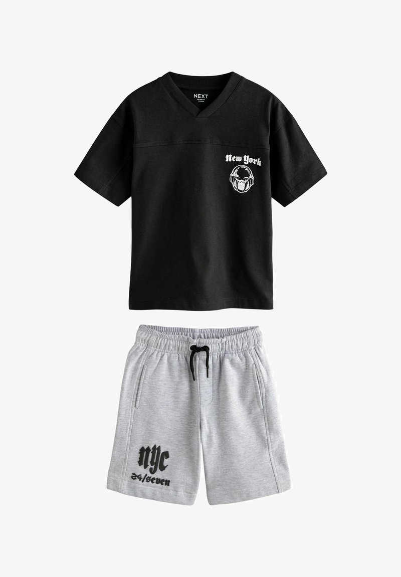 T-shirt noir à manches courtes et col en V avec impression "New York" et casque de singe, associé à un short gris à cordon avec le texte "nyc 24/seven".