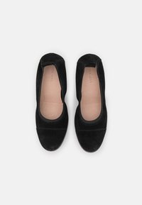 Černé semišové baleríny s kulatou špičkou a elastickými okraji. Interiér má hladké, přírodní kožené podšívku. Bez viditelného kovového příslušenství.