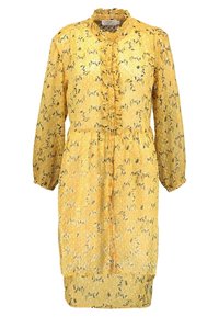 Abito floreale giallo con maniche lunghe, frontale arricciato, chiusura a bottoni e orlo fino al ginocchio. Presenta una texture trasparente e piccoli motivi a foglia.