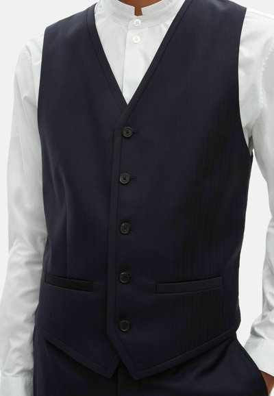 Marineblaues Weste mit scharfem, tailliertem Design. Hat einen V-Ausschnitt, sechs schwarze Knöpfe, zwei Vorderaschen und eine subtile Nadelstreifenstruktur.