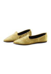 Zapatos deslizantes de terciopelo en amarillo, con punta afilada y suela plana negra. Textura suave con un detalle interior mínimo.