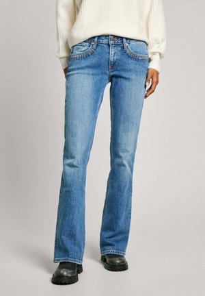 Jeans acampanados de color azul en un lavado medio, con costuras en contraste en los bolsillos, diseño clásico de cinco bolsillos y una cintura de altura media.